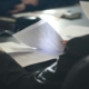 Professional reviewing accreditation standards documents at a conference table
