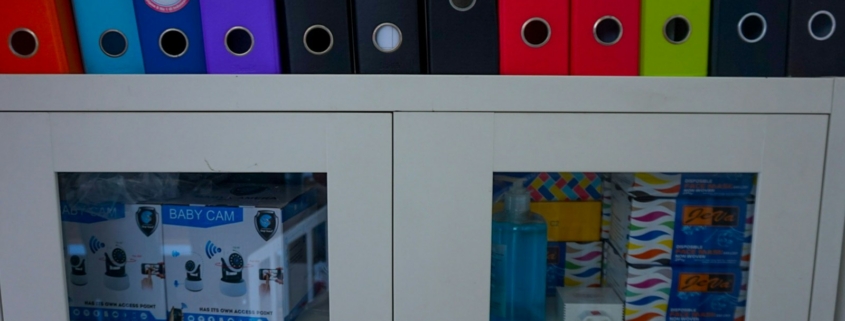 a glass door cabinet with a bunch of folders on top of it