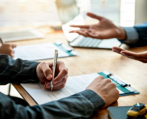 Business people sign investment agreements to buy and sell business.