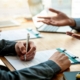 Business people sign investment agreements to buy and sell business.