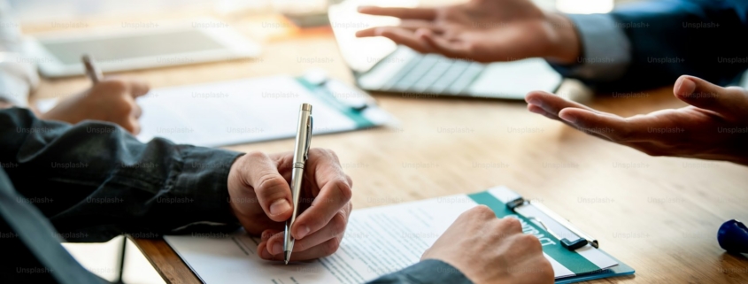 Business people sign investment agreements to buy and sell business.