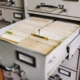 Open file cabinet drawer of patient records illustrating 42 CFR Part 2 confidentiality rules for substance use disorder records