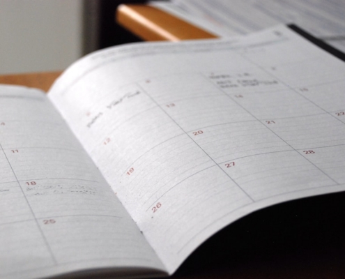 Open monthly planner used to map an annual behavioral health compliance calendar