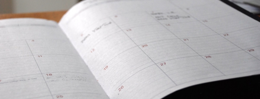 Open monthly planner used to map an annual behavioral health compliance calendar