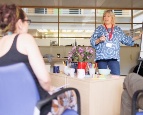 Trainer leading a behavioral health compliance training session at a flip chart