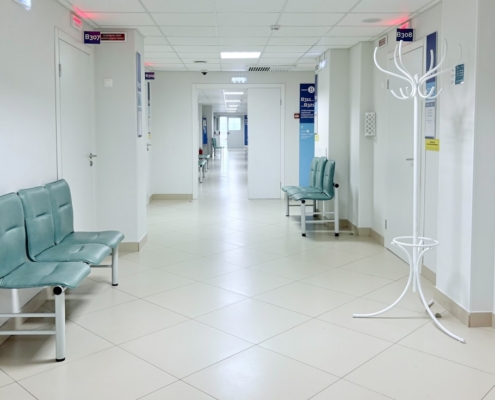 Bright corridor of a residential treatment facility with seating outside patient rooms, illustrating continued stay review documentation