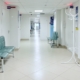 Bright corridor of a residential treatment facility with seating outside patient rooms, illustrating continued stay review documentation
